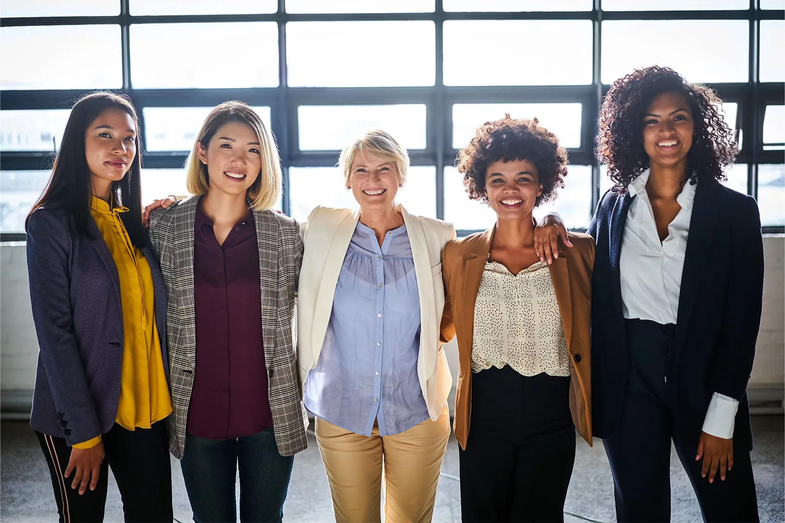 A group of women standing shoulder to shoulder