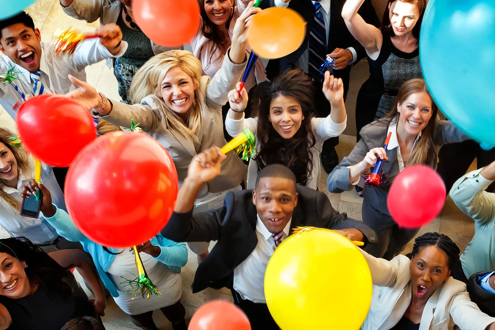 A group of employees celebrating as balloons float into the air