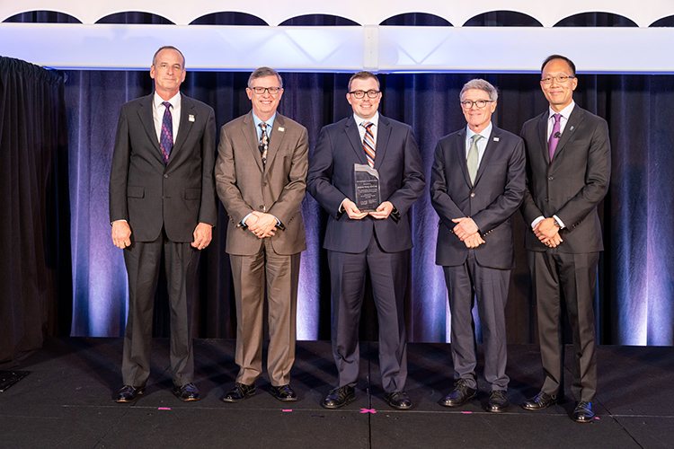 Accepting the Recognition Award on behalf of Brigham Young University was Parker Davis [center], shown here with IMA senior staff and volunteer leaders.