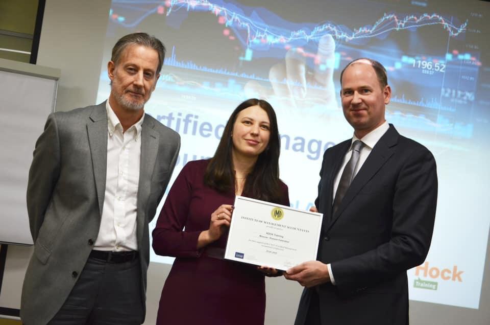 Alain Mulder, on behalf of IMA Europe, presents a certificate of recognition to representatives of HOCK Training. Pictured (l. to r.): Carl Burch, Anna Slavikovskaya, and Alain Mulder.