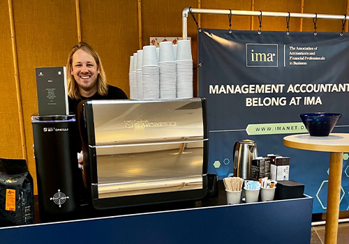 A man smiling at a counter at the EAA conference