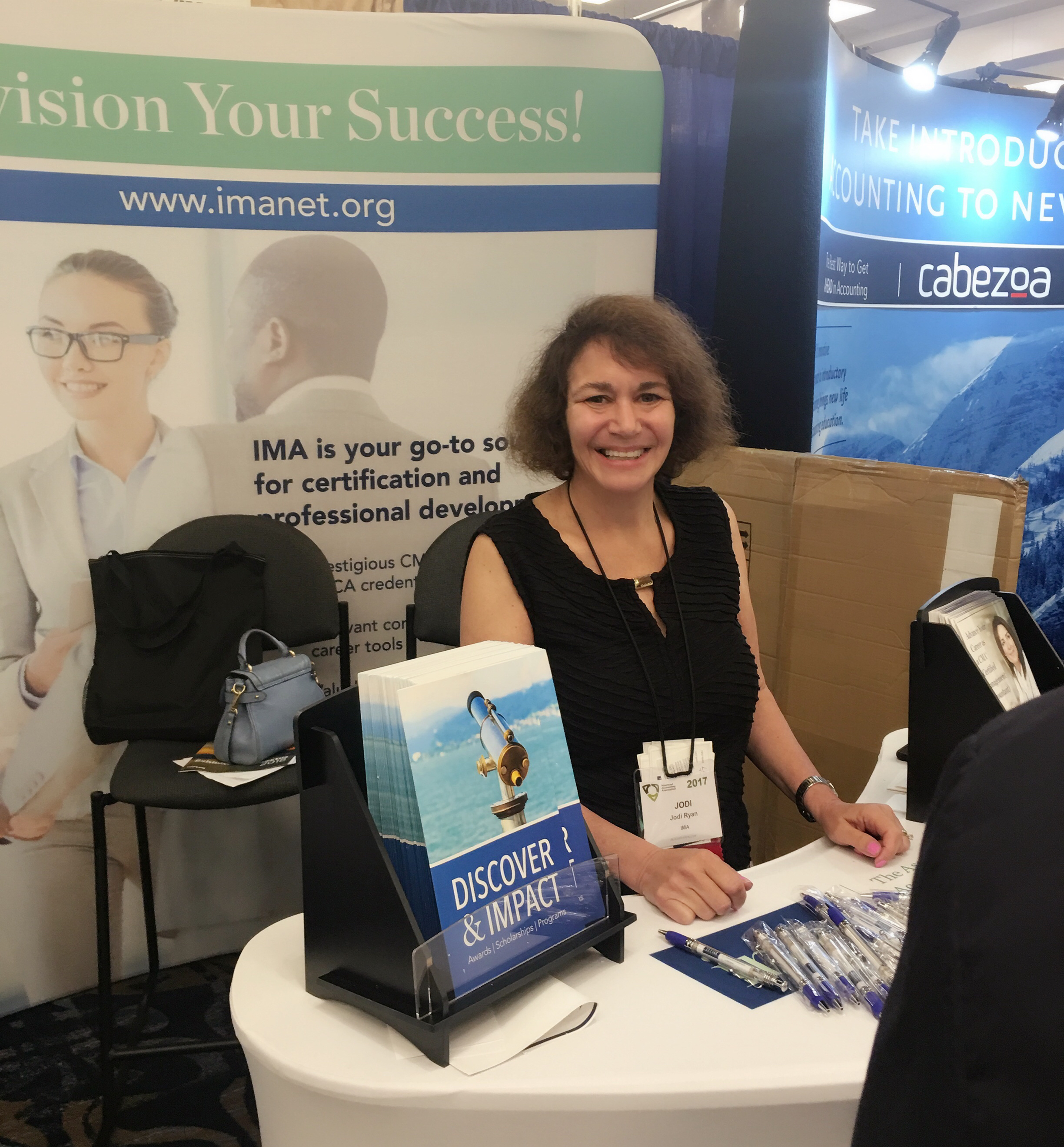 Jodi Ryan, IMA director of student and academic relations, eagerly awaits guests at the IMA booth during AAA.