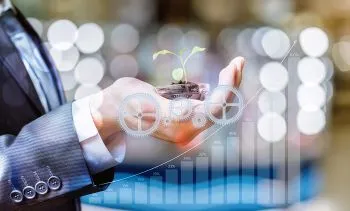 A hand holding a small plant with graphs superimposed