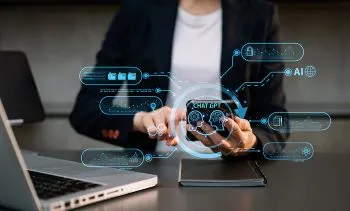 A person seated at a desk using a mobile phone