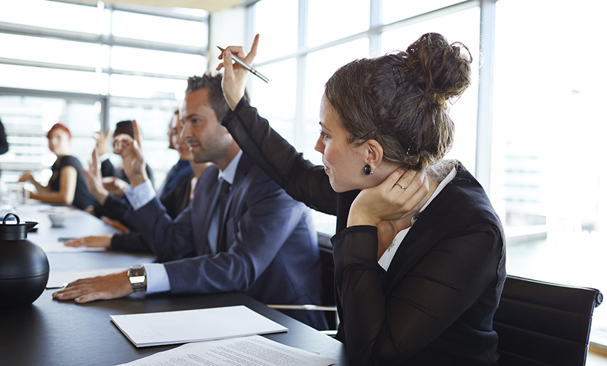 business woman in a meeting raising her hand